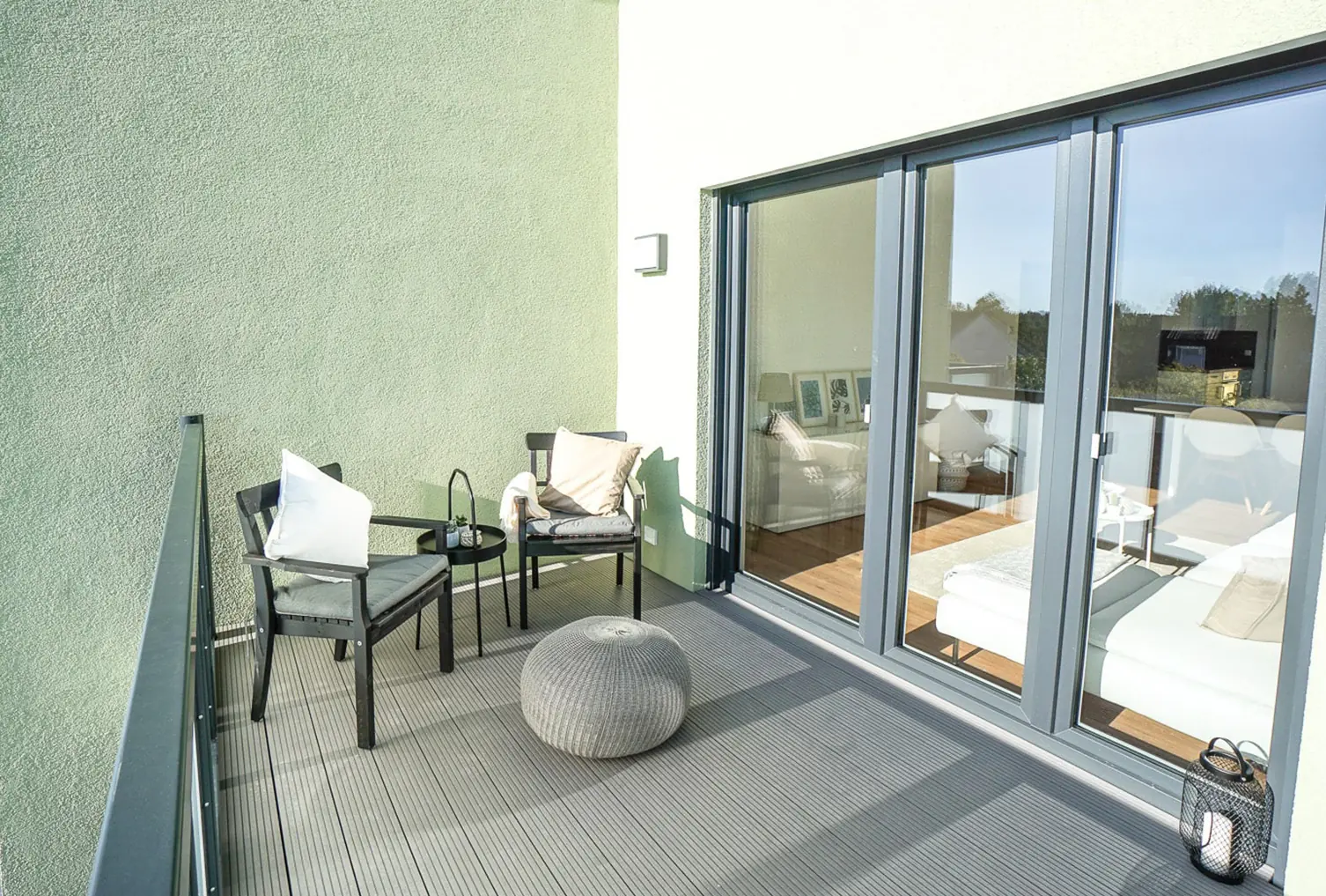 Großzügiger überdachter Balkon mit Sitzbereich und Blick ins Grüne